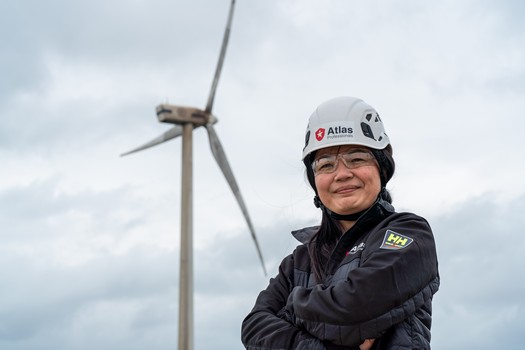風電公司員工站在風機前拍形象照"