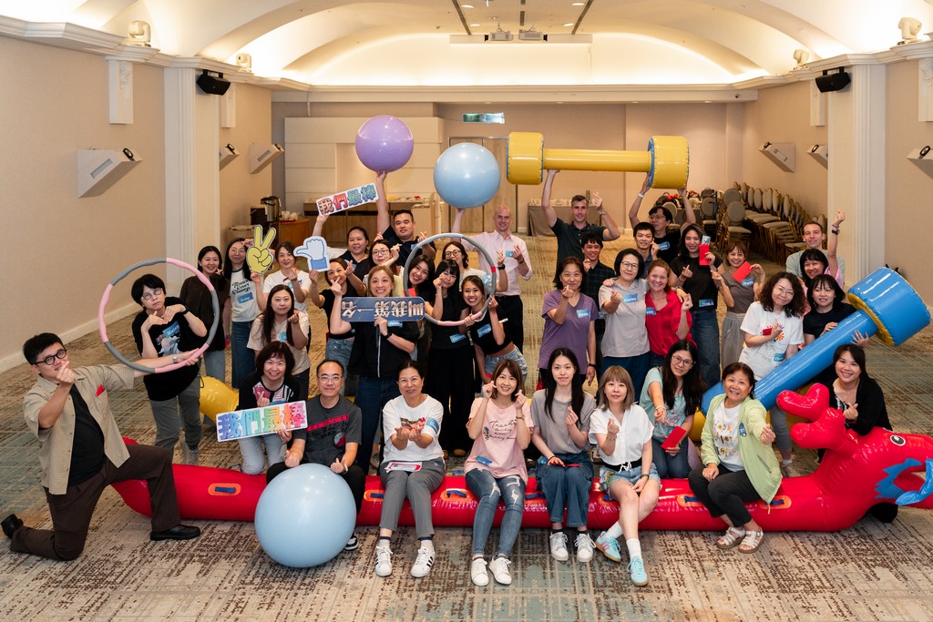 企業活動大合照 – Team Building 圓滿成功全體合影 全體團隊成員手持充氣龍舟、啞鈴與瑜伽球等道具進行 Team Building 圓滿成功大合照