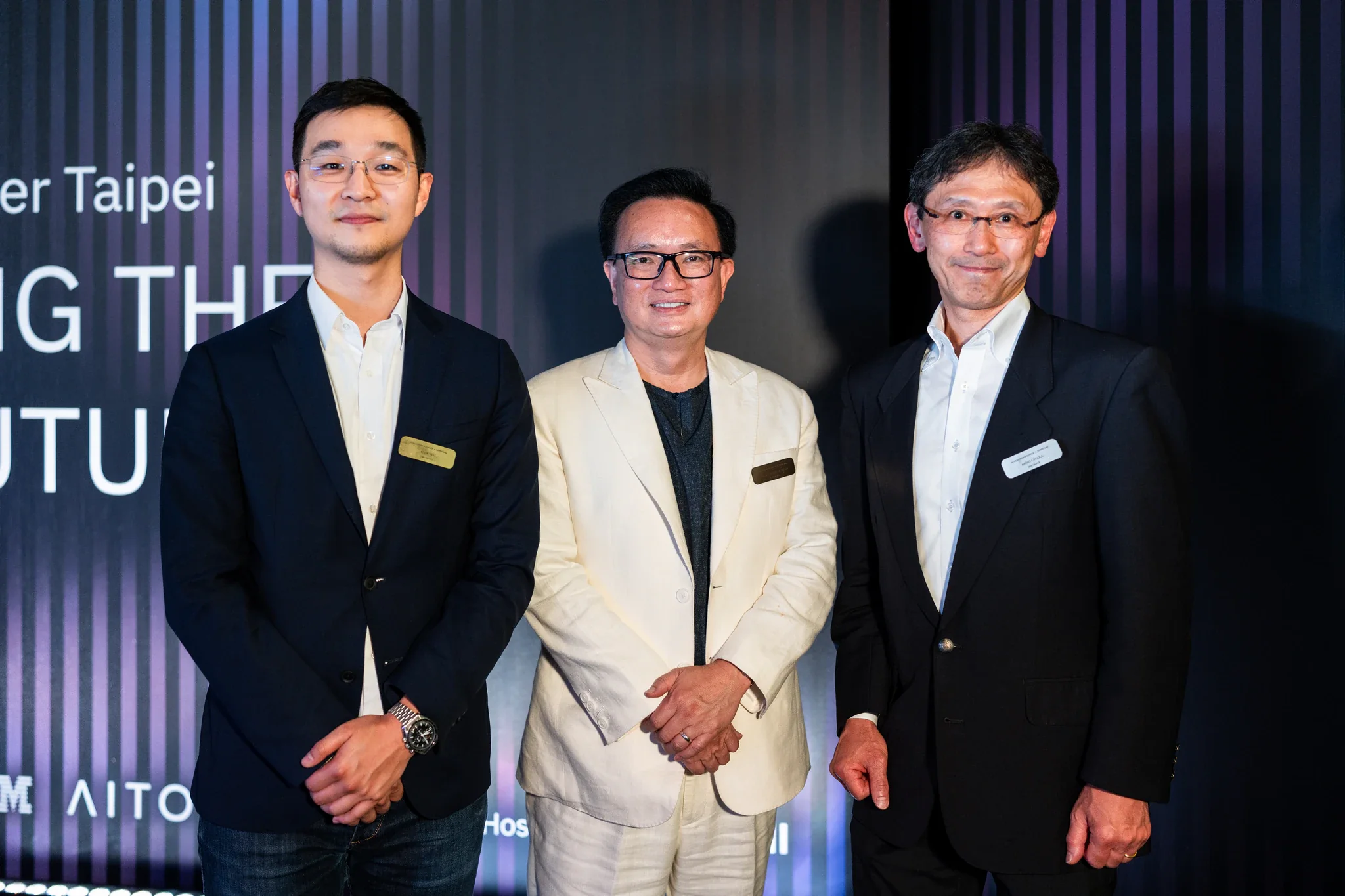 AI Alliance 台北領袖晚宴|貴賓合影 三名男士在印有 AI Alliance 主題的活動背板前站立合照
