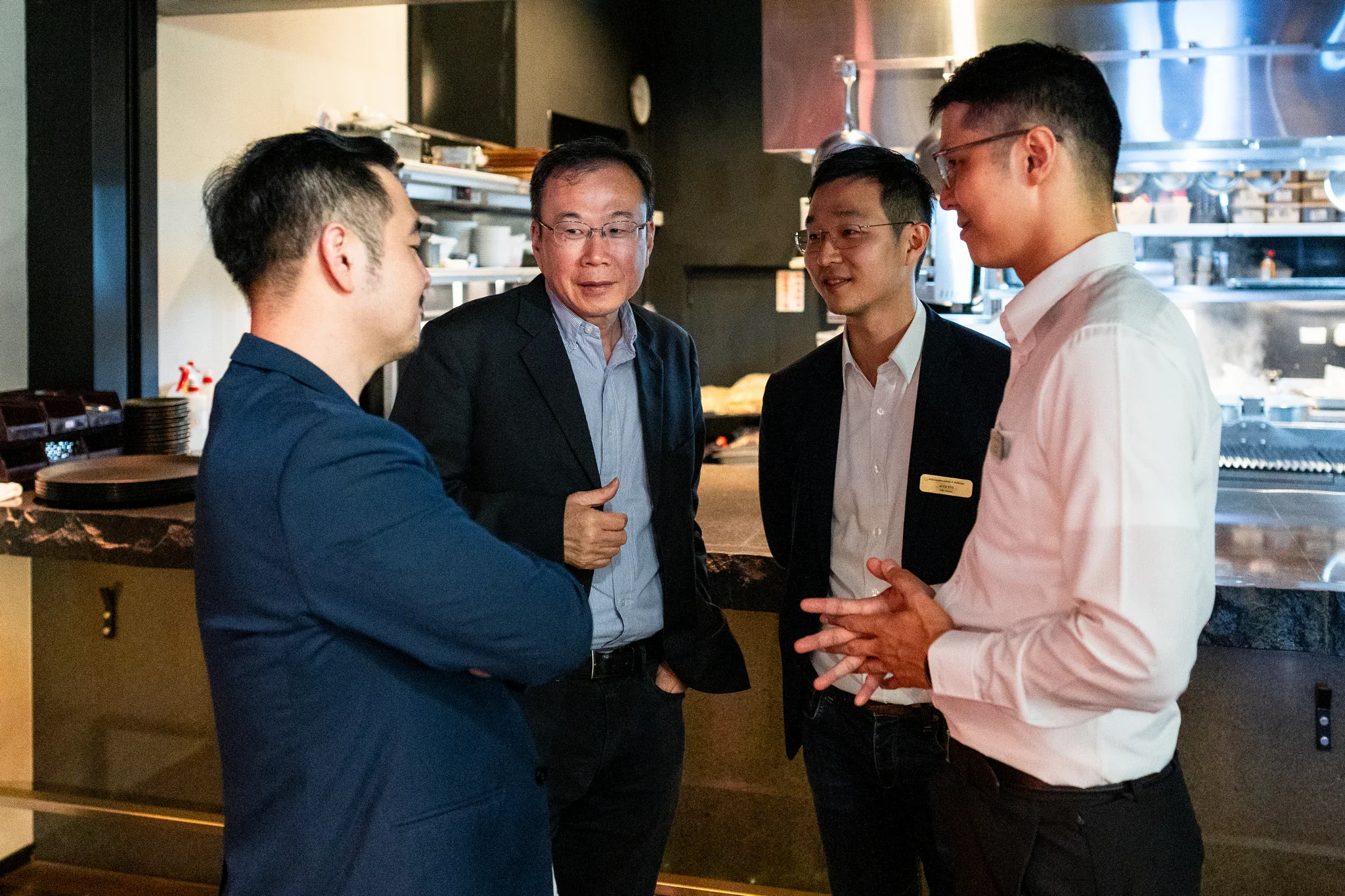 AI Alliance 領袖晚宴|商務人脈交流 數名穿著正式服裝的男士在餐會場地交流