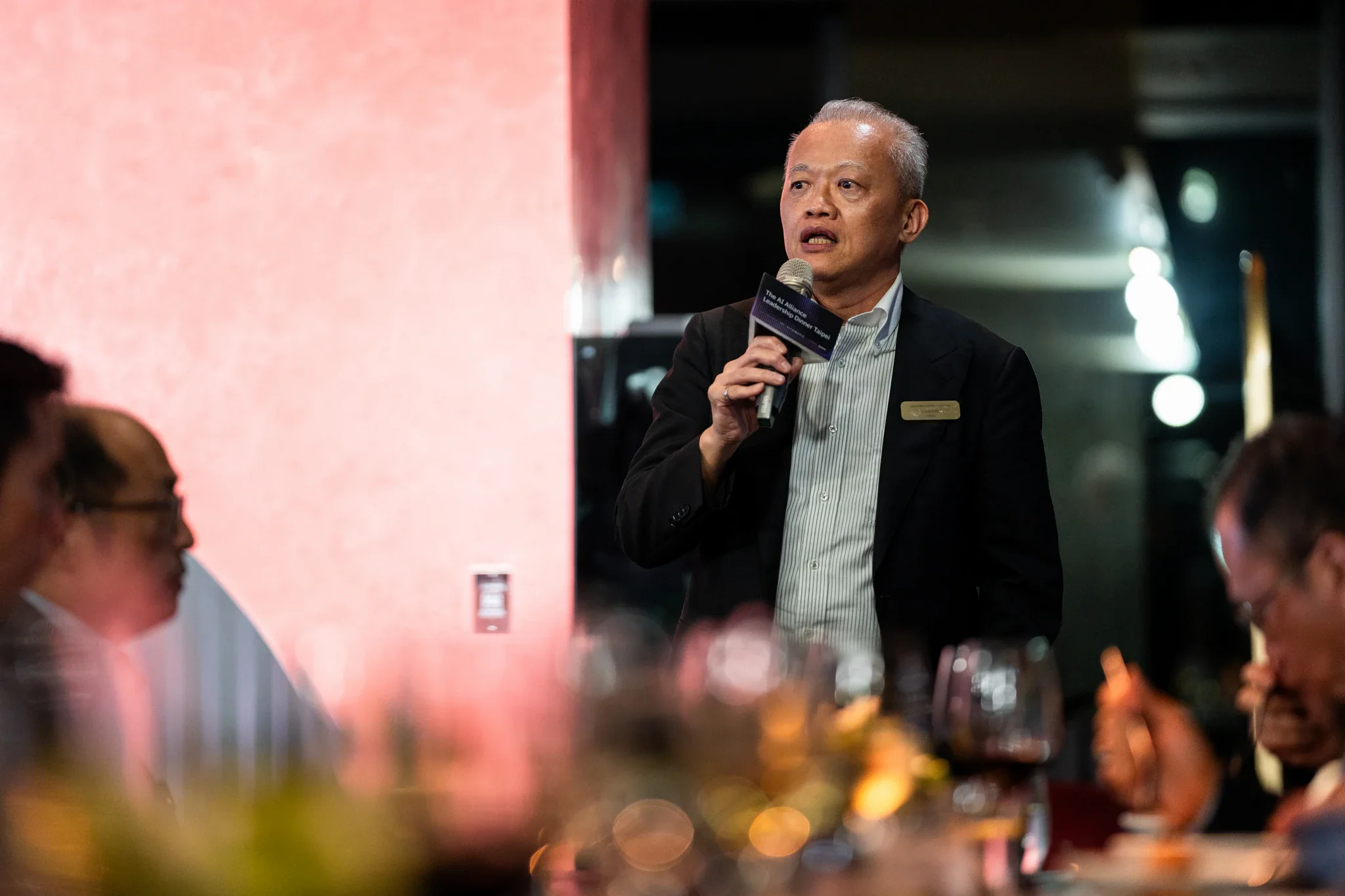 AI Alliance 晚宴活動|嘉賓發言 一名年長男講者手持麥克風對著晚宴來賓分享