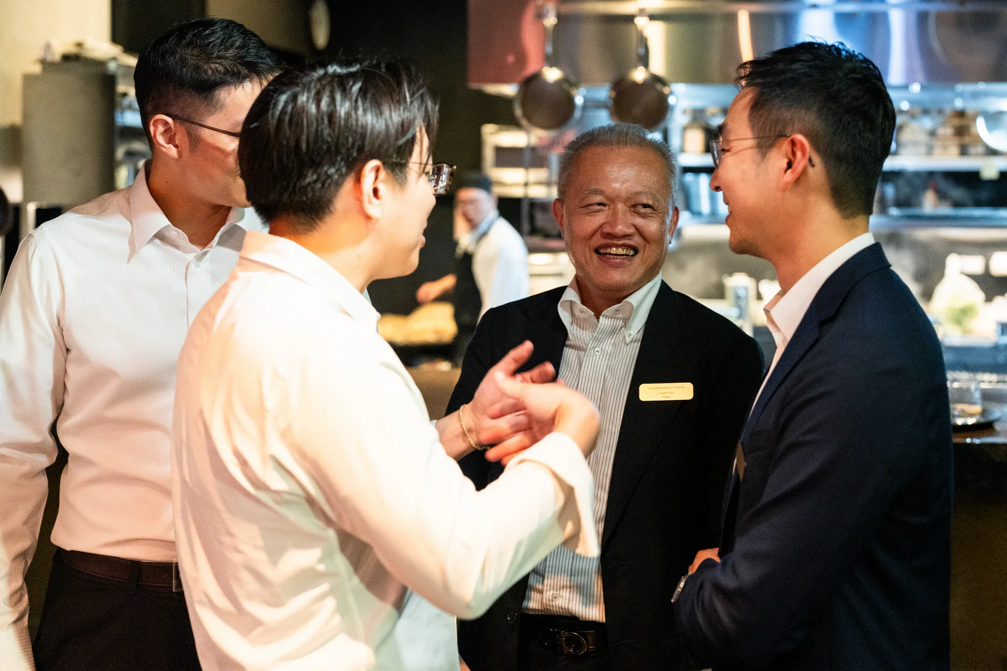 AI Alliance 晚宴|商務貴賓握手 商務來賓在晚宴現場交流並握手,周圍可見餐會環境