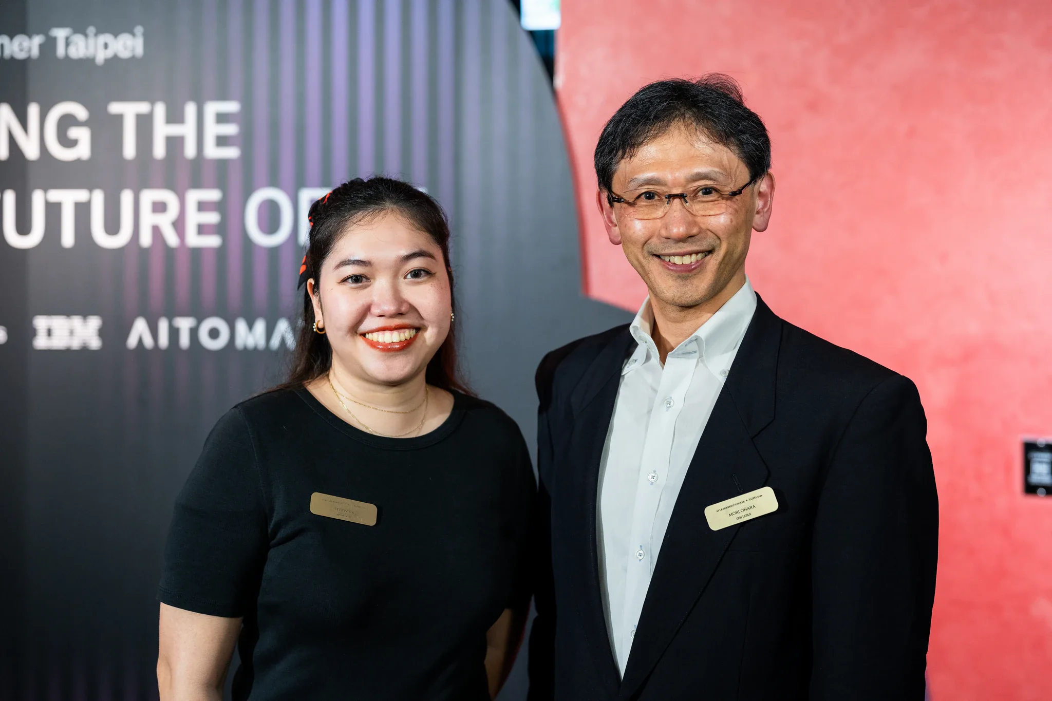 AI Alliance 晚宴|賓客雙人合照 一男一女在 AI Alliance 主題背板前面向鏡頭合影
