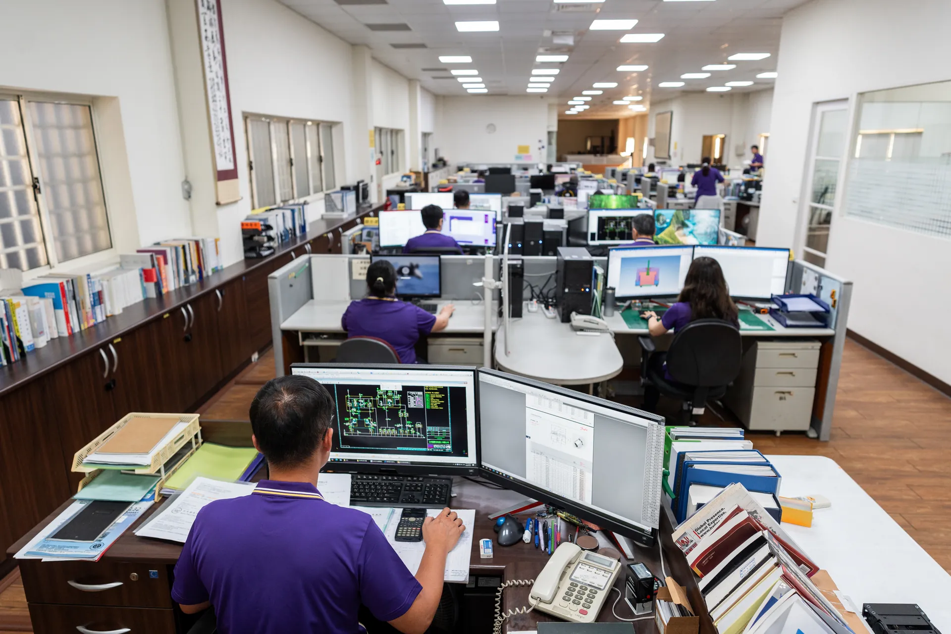 協聚德企業形象攝影|工程辦公室全景 協聚德工程辦公室全景,多位員工在長型工作空間內使用電腦